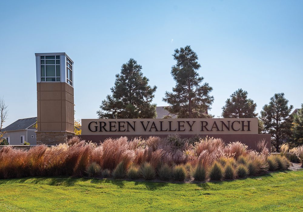 Entrance sign of Green Valley Ranch community with surrounding trees and landscaping