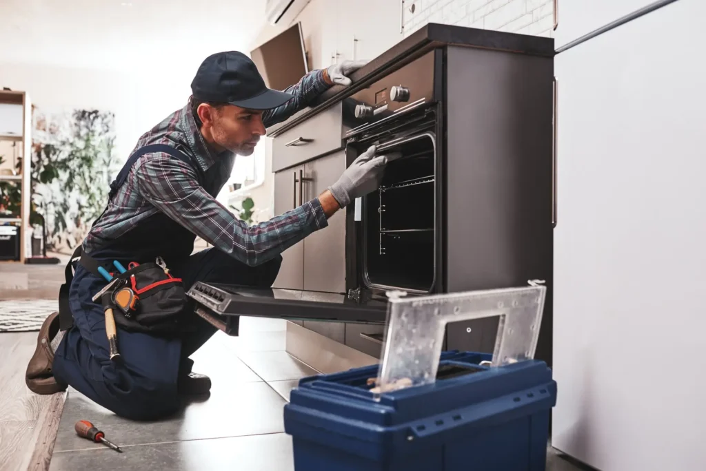 Technician repairing an oven in a modern kitchen