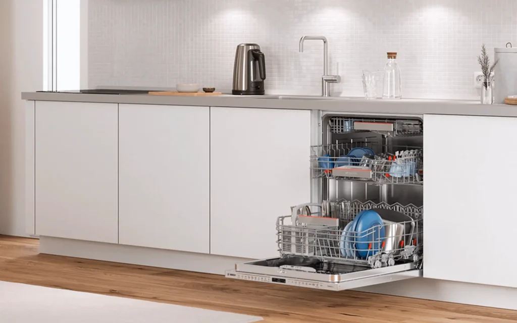Modern kitchen with an open dishwasher containing clean dishes