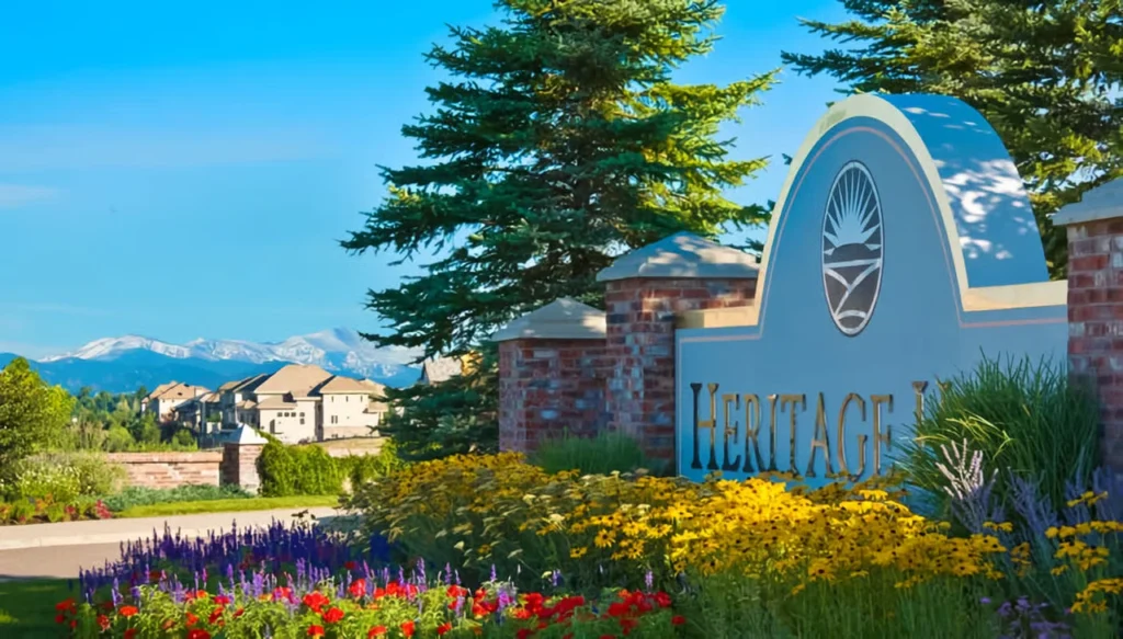 Heritage Hills community entrance with landscaped flowers and distant mountains