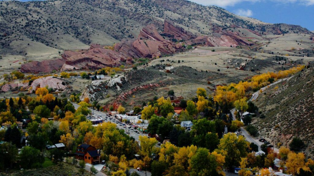 Aerial view of Morrison, Colorado with autumn trees and red rock formations in the background