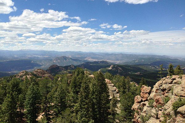 Scenic mountain landscape near Sedalia, Colorado with a view of Rocky Mountains under a clear blue sky.