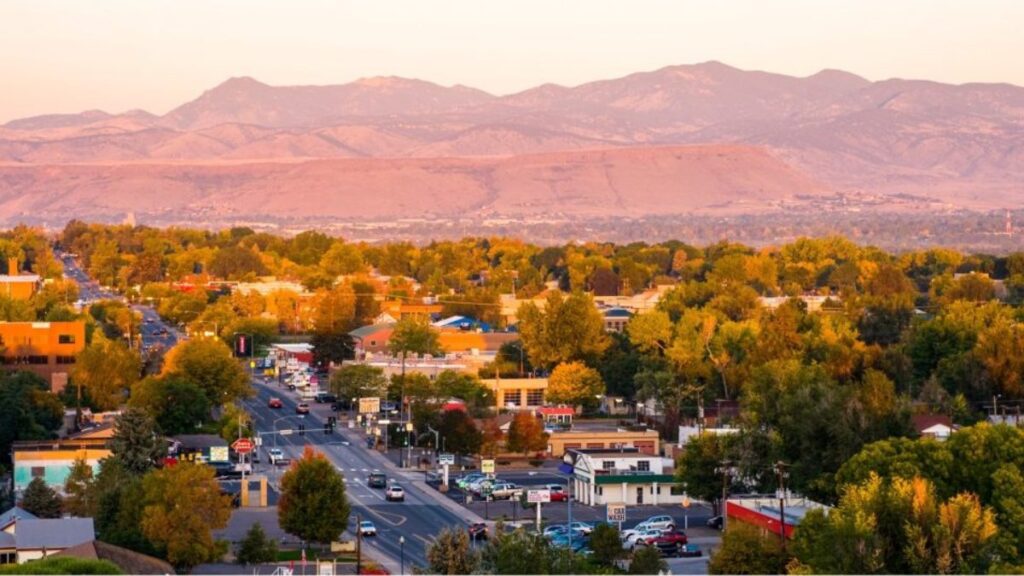 Scenic view of Wheat Ridge, Colorado with mountains and cityscape at sunset
